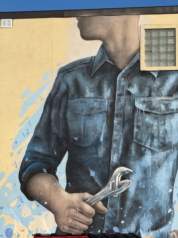 Ryan Smeeton's Mural for Ottawa's Wellington West depicting a faceless figure with a wrench