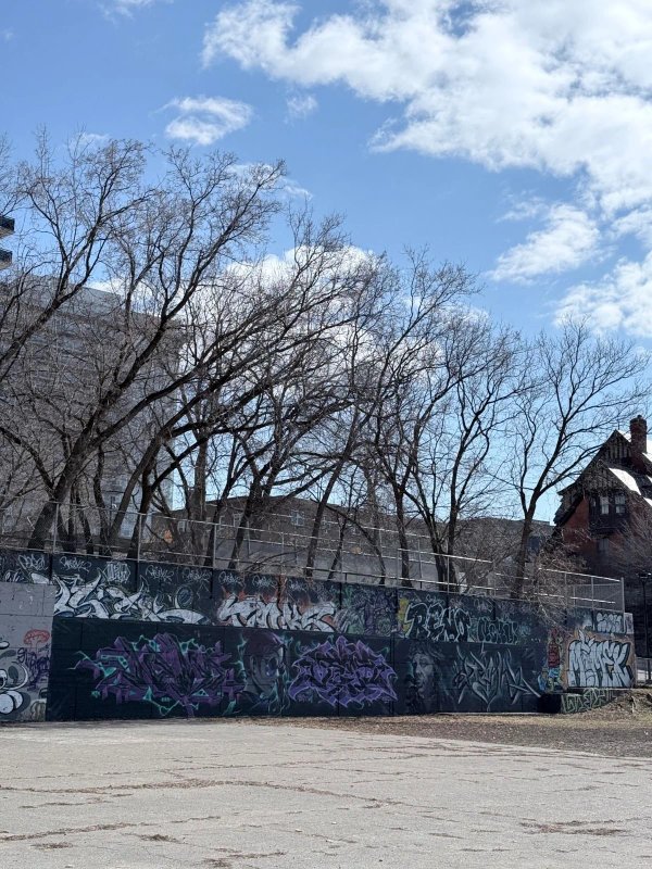 Close-up of layered spray paint and graffiti art on the concrete slabs of the Tech Wall in Ottawa, highlighting years of accumulated paint.