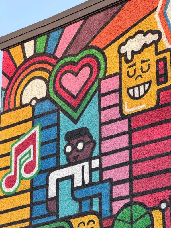 A dynamic and colorful public mural on Rue Eddy in downtown Gatineau created by Loogart and Phil Landry as part of the Eddy en couleur street revitalisation project, showcasing local neighborhood spirit through playful pop culture and coffee shop imagery.