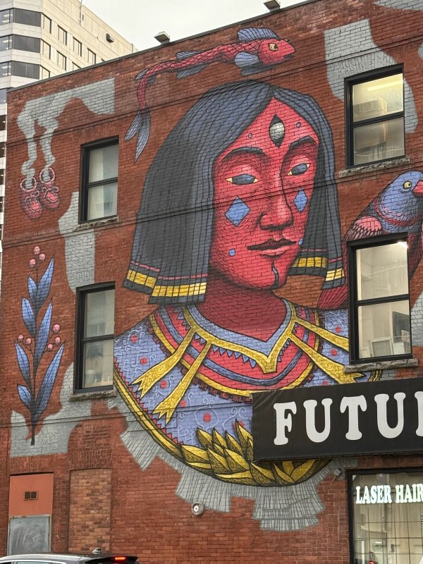 Urban Art Index: SbuOne's animistic figurative mural of a powerful red-faced deity and bird. Ancient-inspired street art in Ottawa's vibrant arts scene.