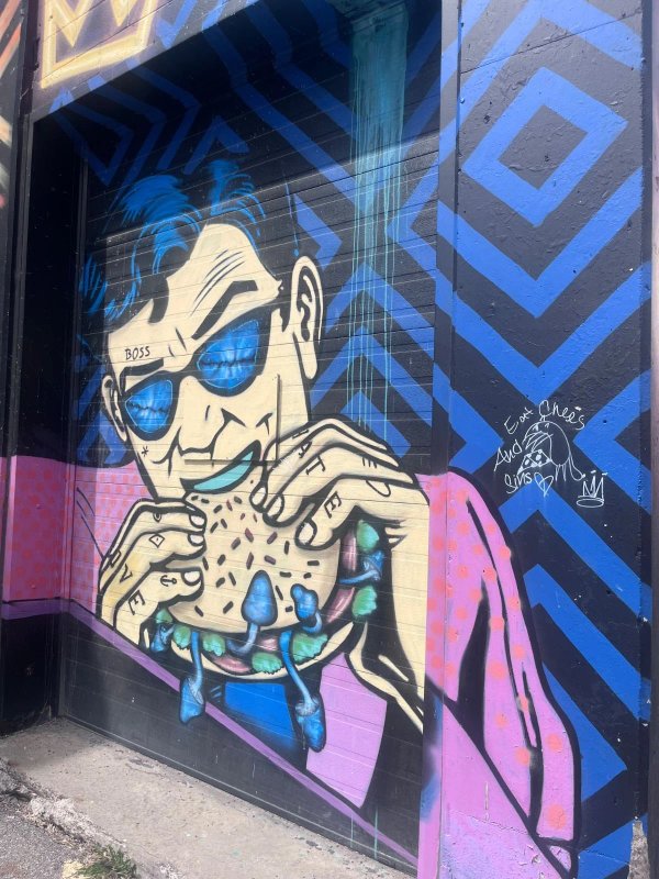 Détail d'art urbain psychédélique montrant des zigzags géométriques et des carrés par les artistes Phil Landry et Marin Mitrasinovic