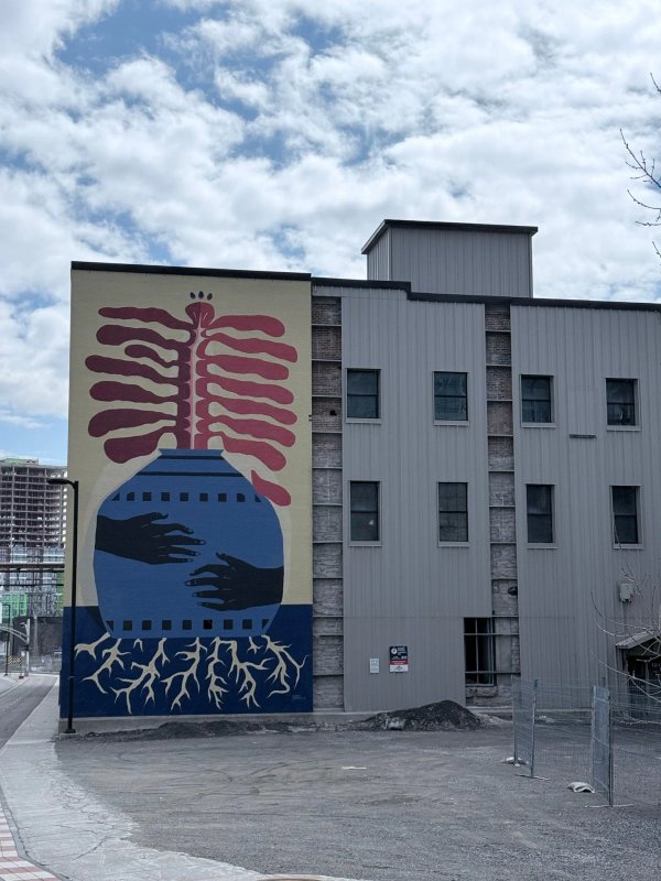 Street art Gatineau Hull district, We Are Seeds mural by Latin Canadian artist Claudia Gutierrez on the side of a tall industrial building on Eddy St.