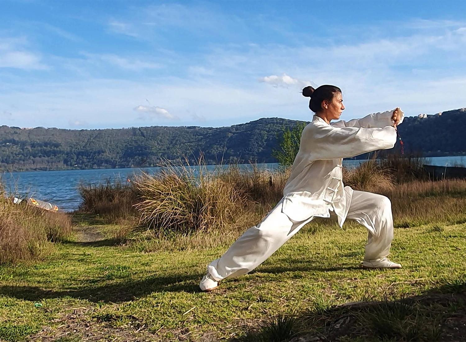 Carolina Inda pratica Taiji Quan all’aperto davanti al lago.