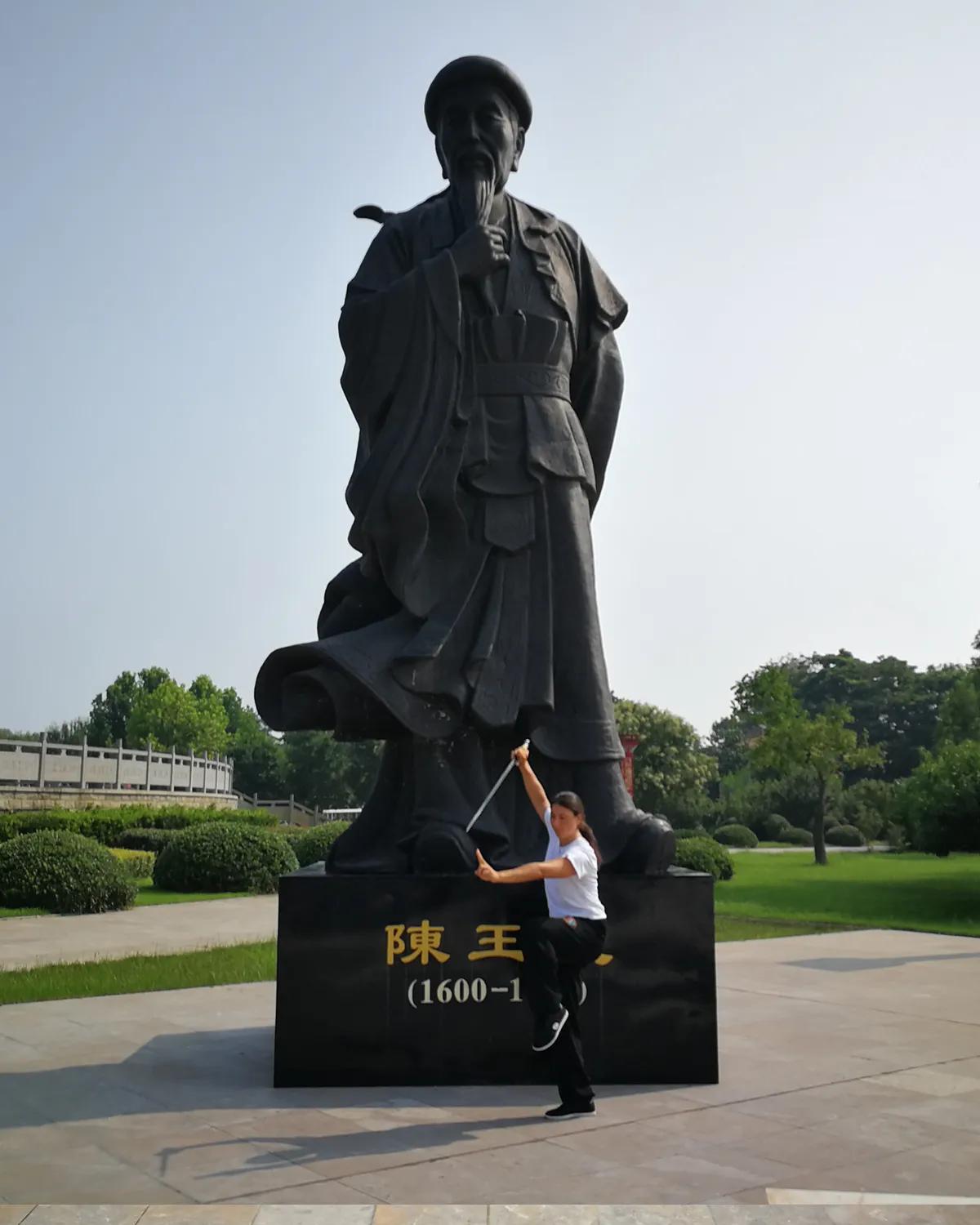 Carolina Inda in una posa di Taiji Quan davanti alla statua di Chen Wangting.