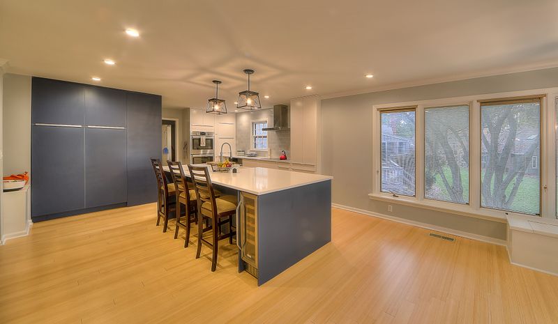 Kitchen island with bar seating open to the dining space after removing a dividing wall
