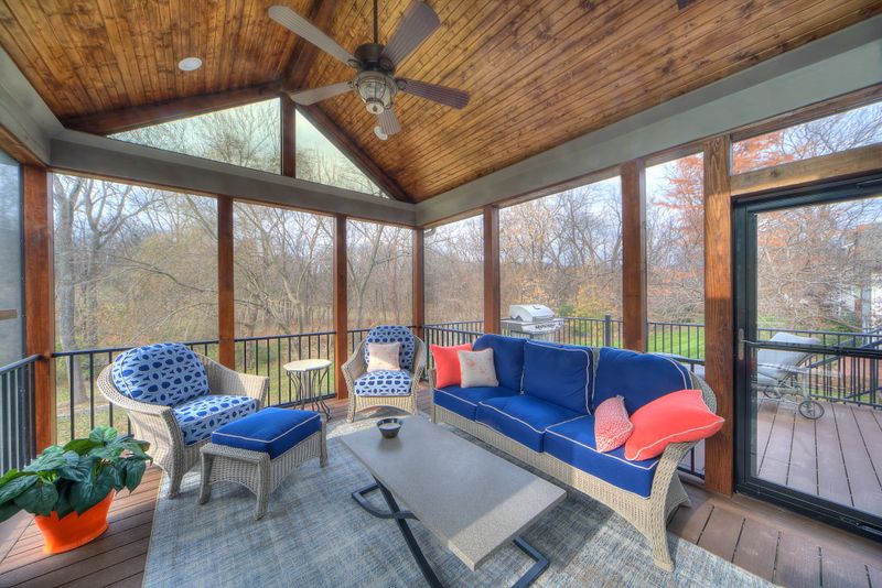 Sunroom interior with a wood plank ceiling, ceiling fan, and windows on three sides