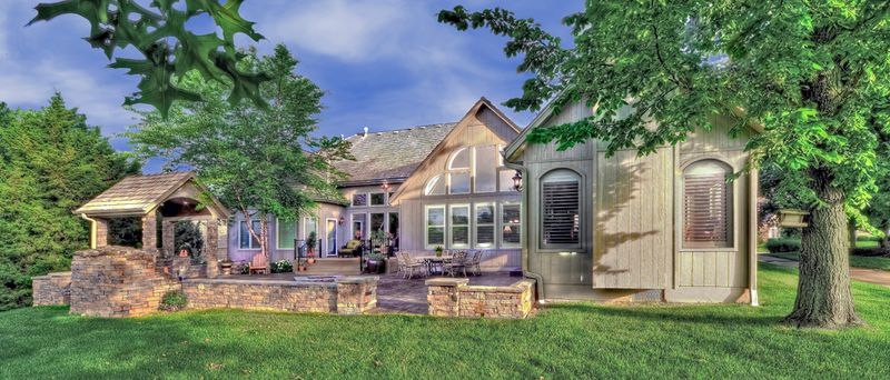Exterior of a glass-gabled sunroom addition with stone patio by All Under One Roof, Kansas City