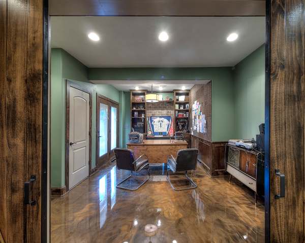 Finished basement office by All Under One Roof with metallic epoxy floor and custom built-in shelving, Kansas City