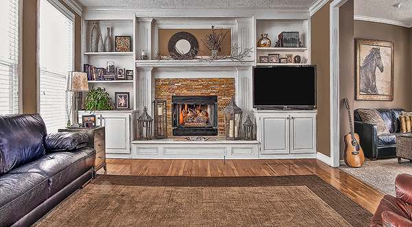 Interior renovation by All Under One Roof with stone fireplace surround and custom built-in cabinetry, Kansas City