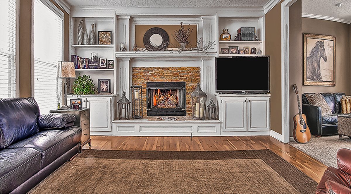 Interior renovation by All Under One Roof with stone fireplace surround and custom built-in cabinetry, Kansas City