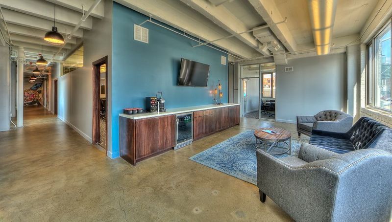 Open office break area with lounge seating and polished concrete floors