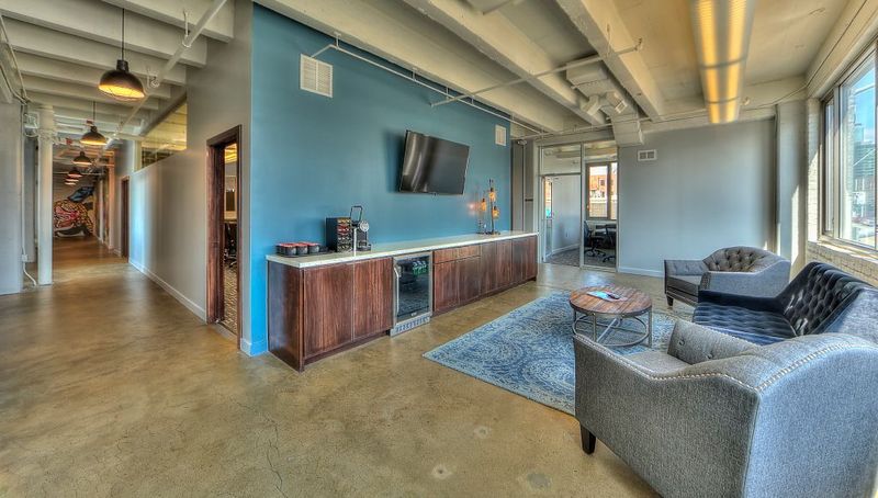 Open office break area with lounge seating and polished concrete floors