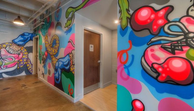 Office corridor with a custom painted mural and finished restroom entry