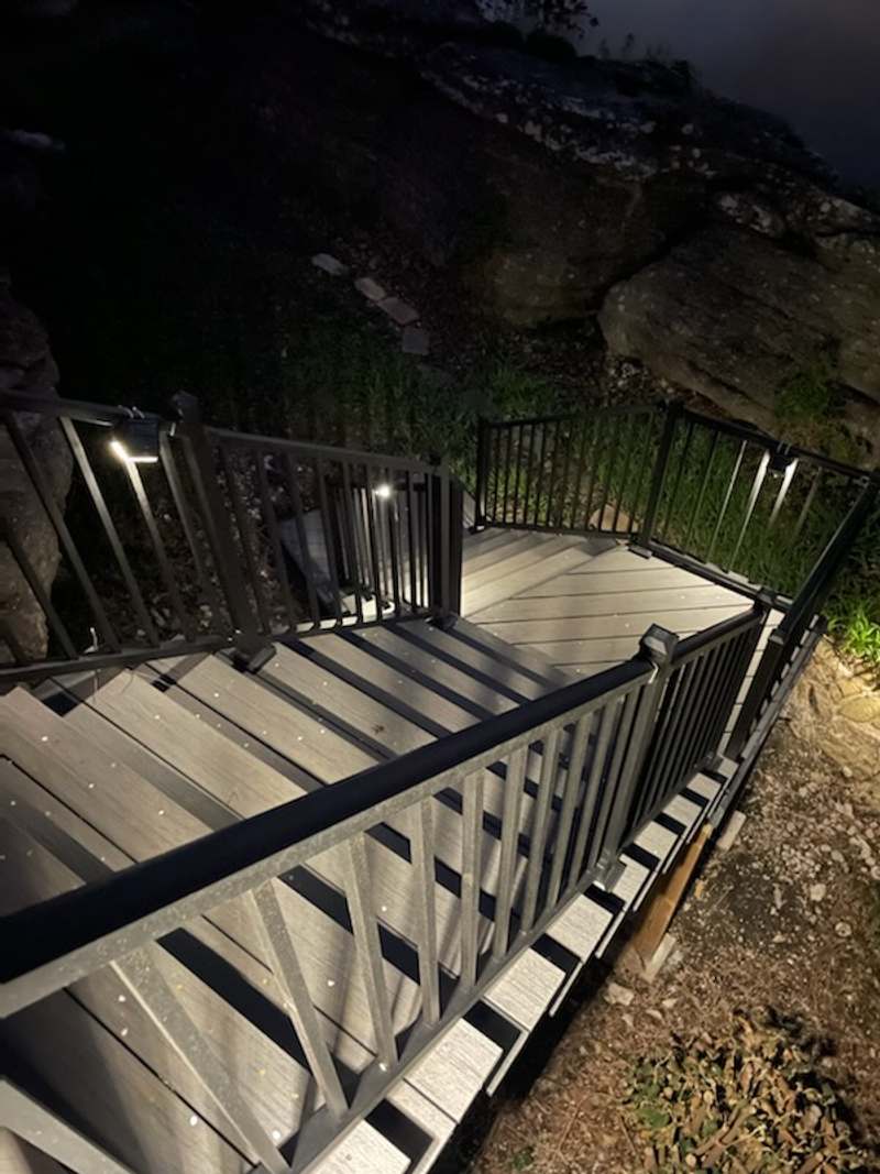 Lit aluminum rail posts along the stair at night