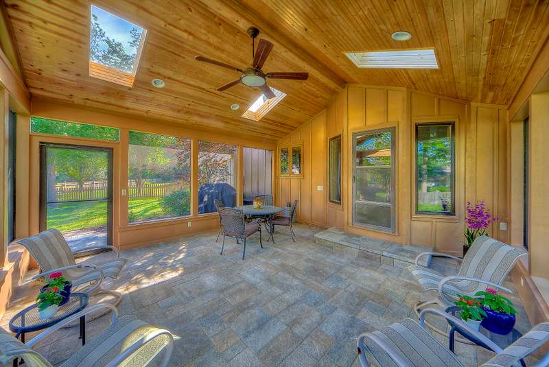 Inside the porch: a vaulted tongue & groove ceiling with skylights & a ceiling fan over a paver floor
