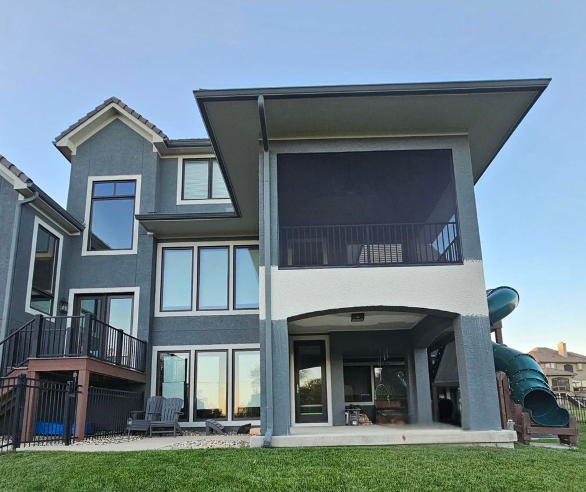 The finished rear elevation in Olathe, with the screened porch above, the deck & stair below, & the slide running down to the lawn
