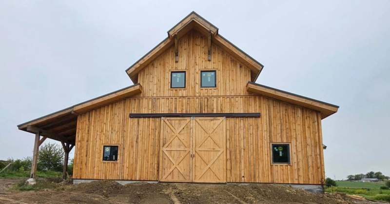 A wide view of the completed building, with the gable end & the covered porch running back along the elevation