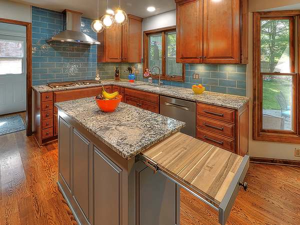 Custom kitchen remodel by All Under One Roof with blue glass tile backsplash, granite island and cherry cabinetry, Kansas City