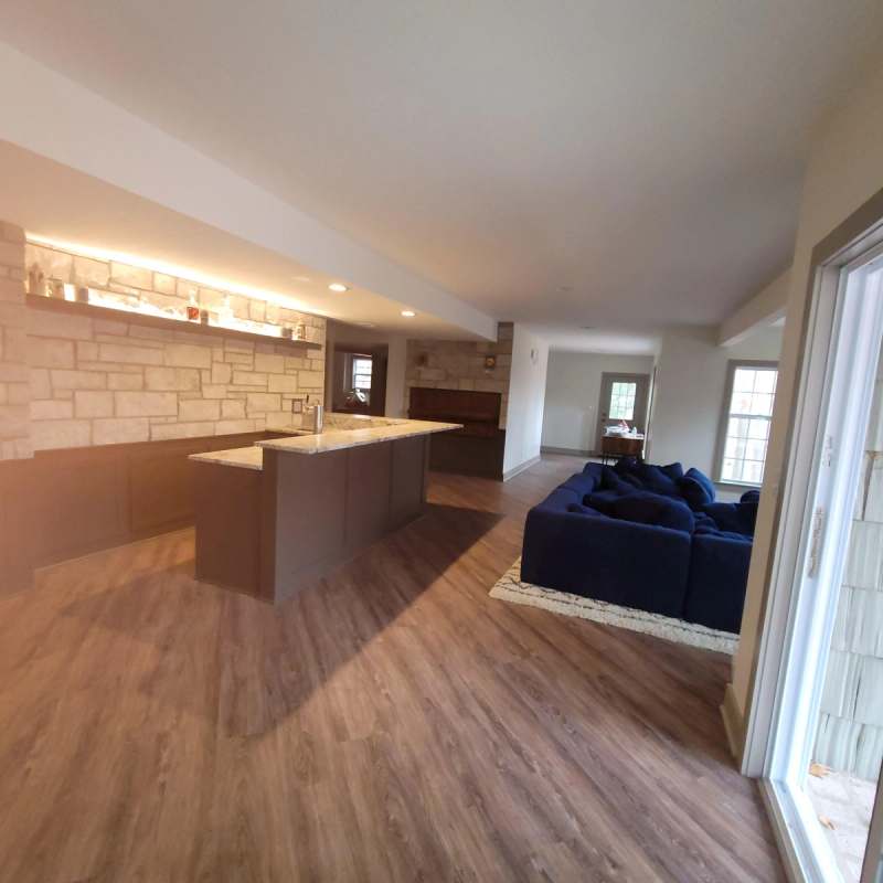 The bar run & the basement family room beyond, with vinyl plank floors throughout