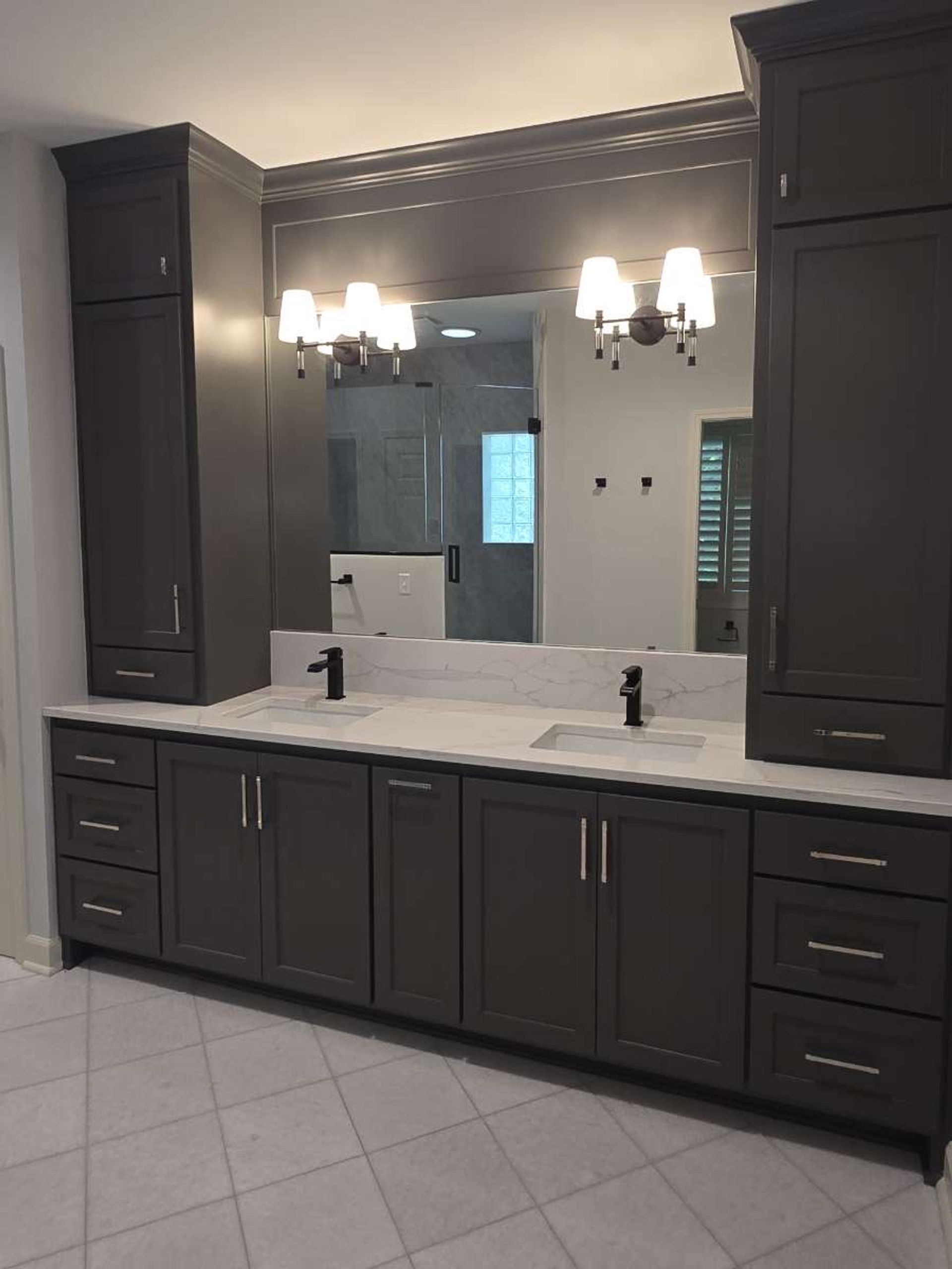 Completed master bathroom in Lenexa, Kansas with a double quartz topped vanity, charcoal shaker cabinetry & two full height linen towers