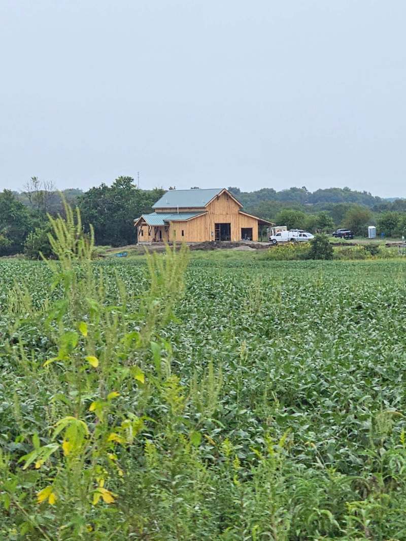 The barndominium seen from across the field, which gives a sense of the 40 acre site it sits on