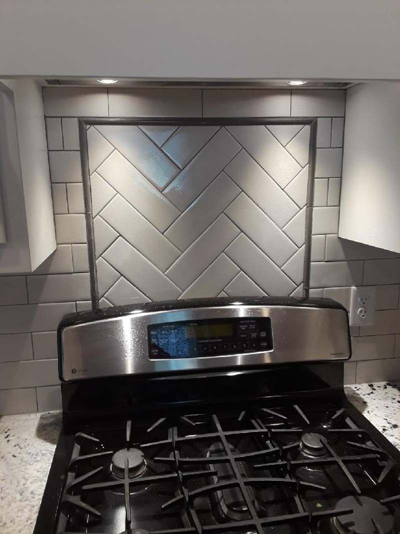 Herringbone subway tile framed behind the gas range