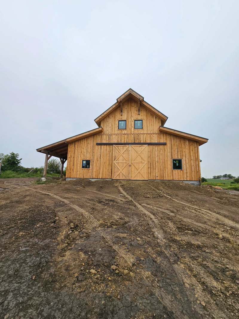 The gable end of the finished building, with the loft windows set above the main opening