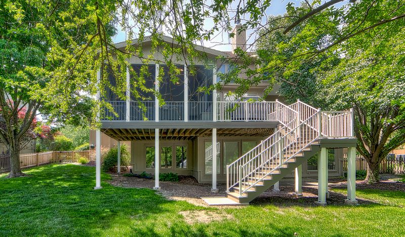 Elevated screened porch with deck stairs, exterior view