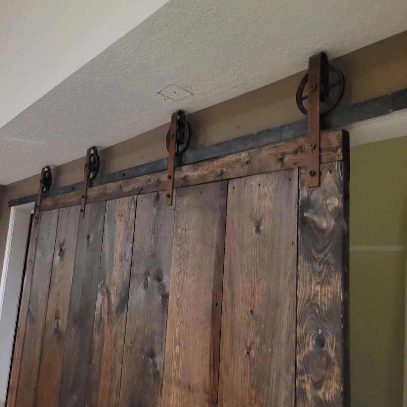 Barn door hardware on a black iron track