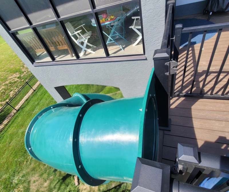 The slide entry set into the deck rail, with the finished deck boards running back to the house