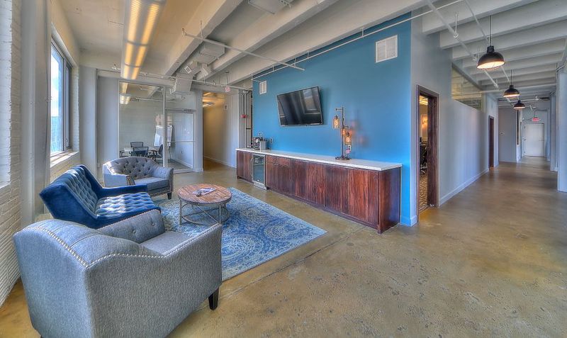 Office lounge and break area with a coffee bar and mounted TV in a Kansas City commercial space