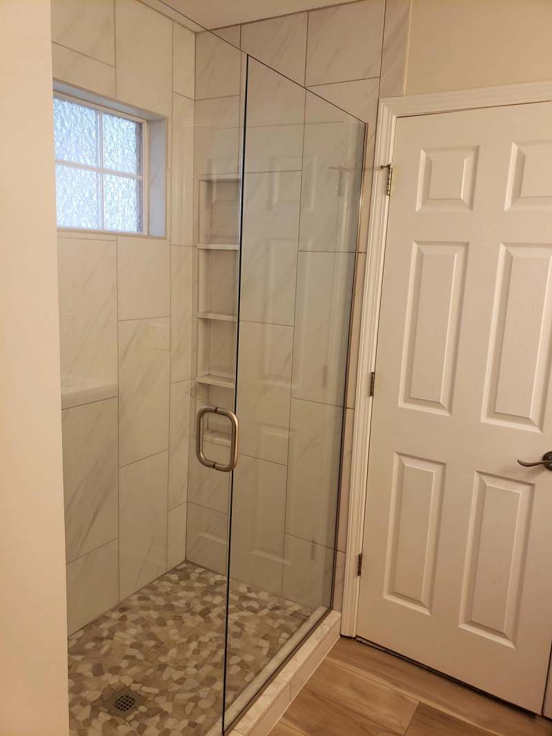 The shower with a recessed shelf niche & a pebble tile floor