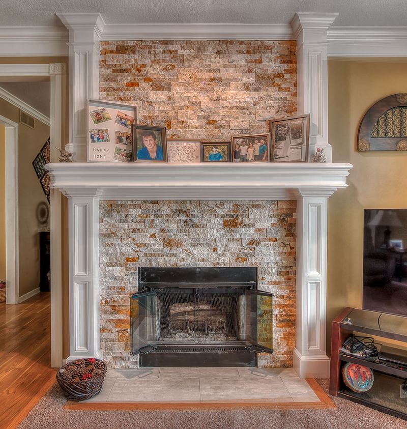 Rebuilt fireplace with a painted mantel and brick surround in a renovated Kansas City living room