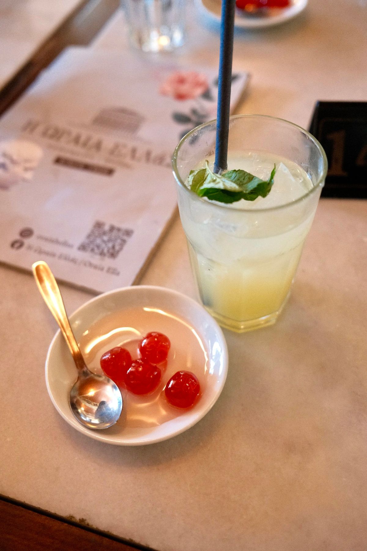 Mint lemonade and a candied fruit dessert on a marble cafe table in Athens