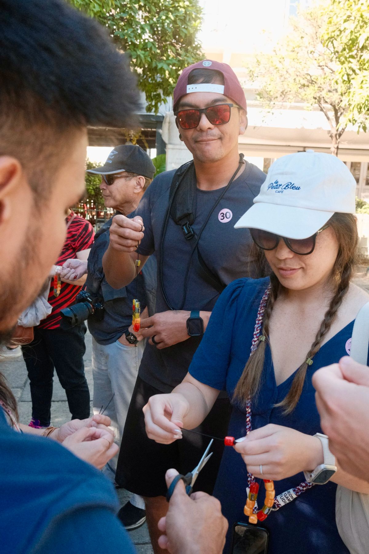 Friends gather around to string beads onto cords during the komboloi-making workshop