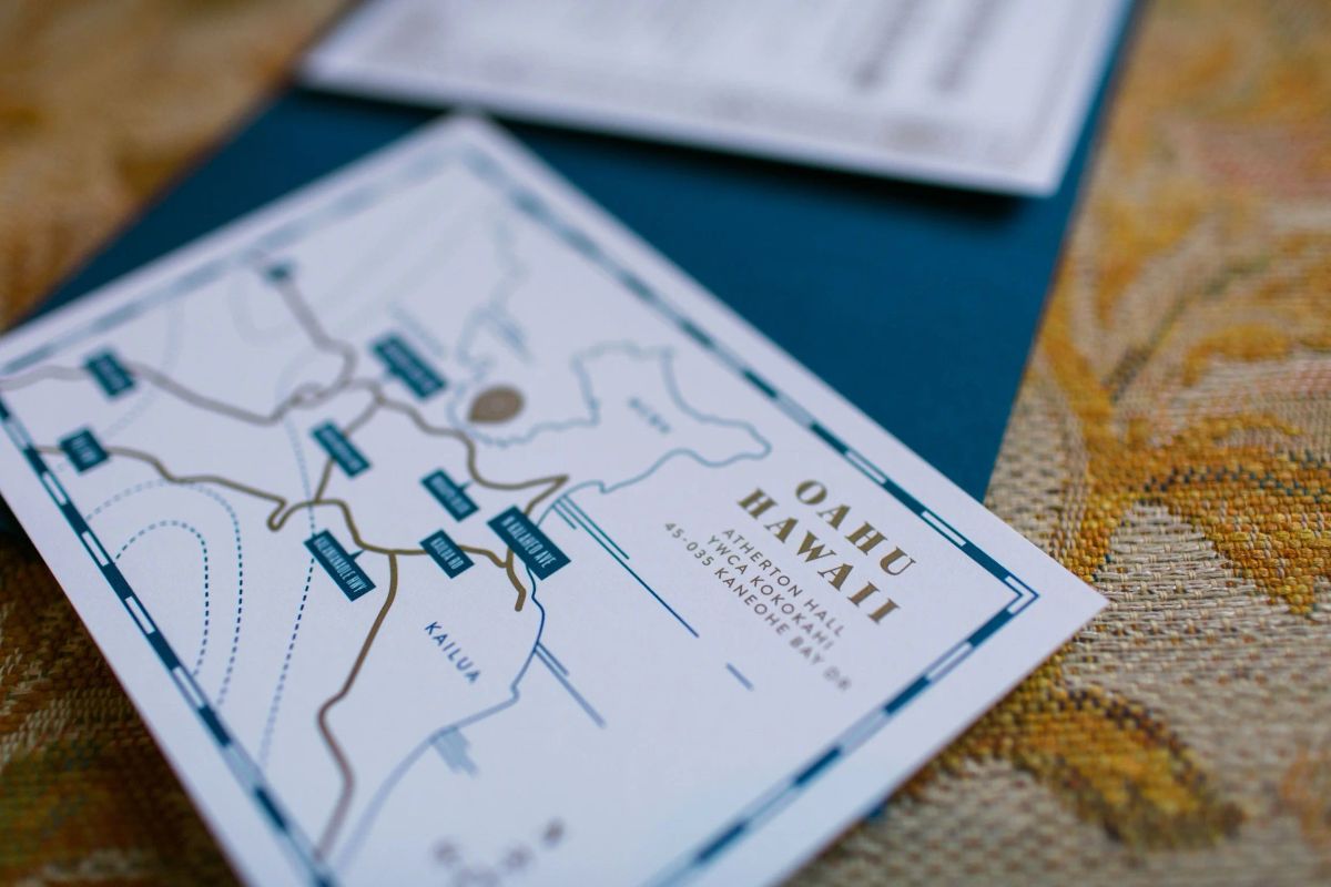 Close-up of an illustrated Oahu, Hawaii map card for the wedding, showing roads and labeled stops in blue and gold