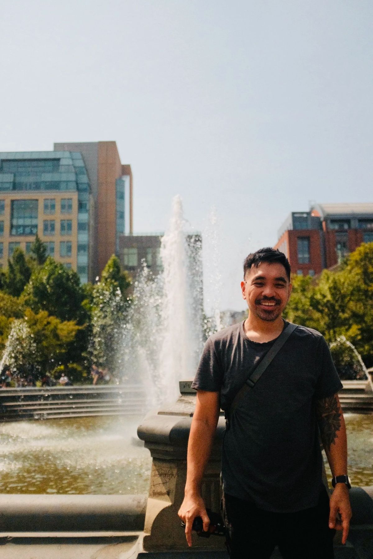 Mark smiling in front of the Washington Square Park fountain