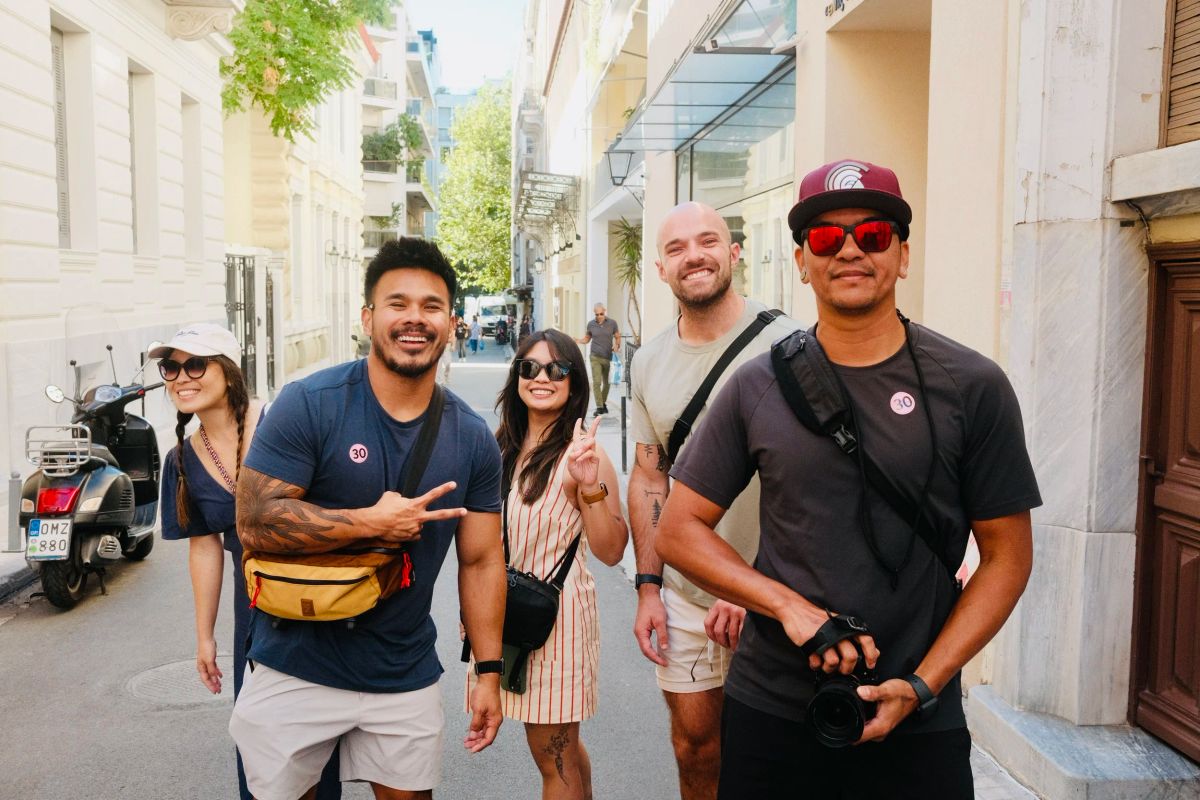 Five friends posing together on a narrow street in Athens