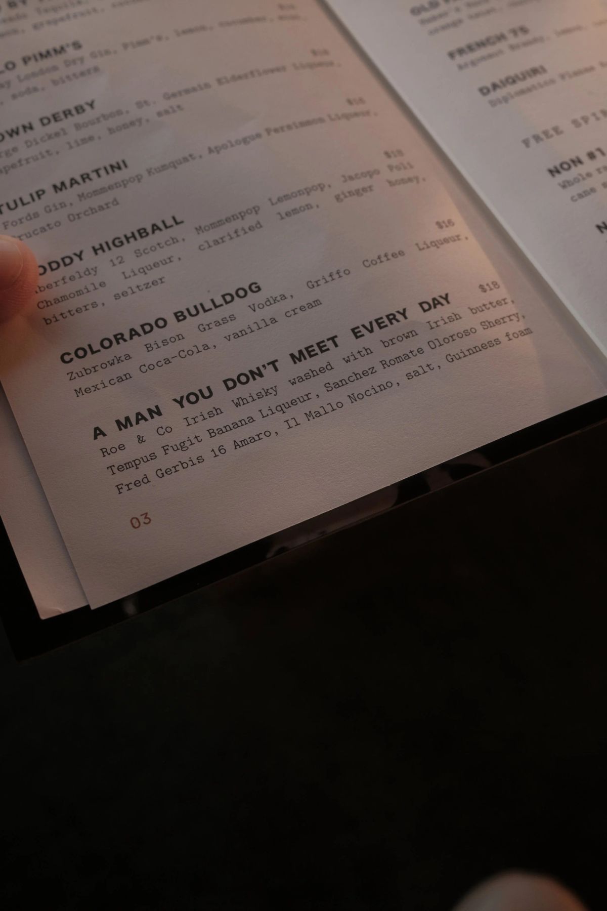 Close-up of a cocktail menu page listing drinks such as Colorado Bulldog and A Man You Don't Meet Every Day