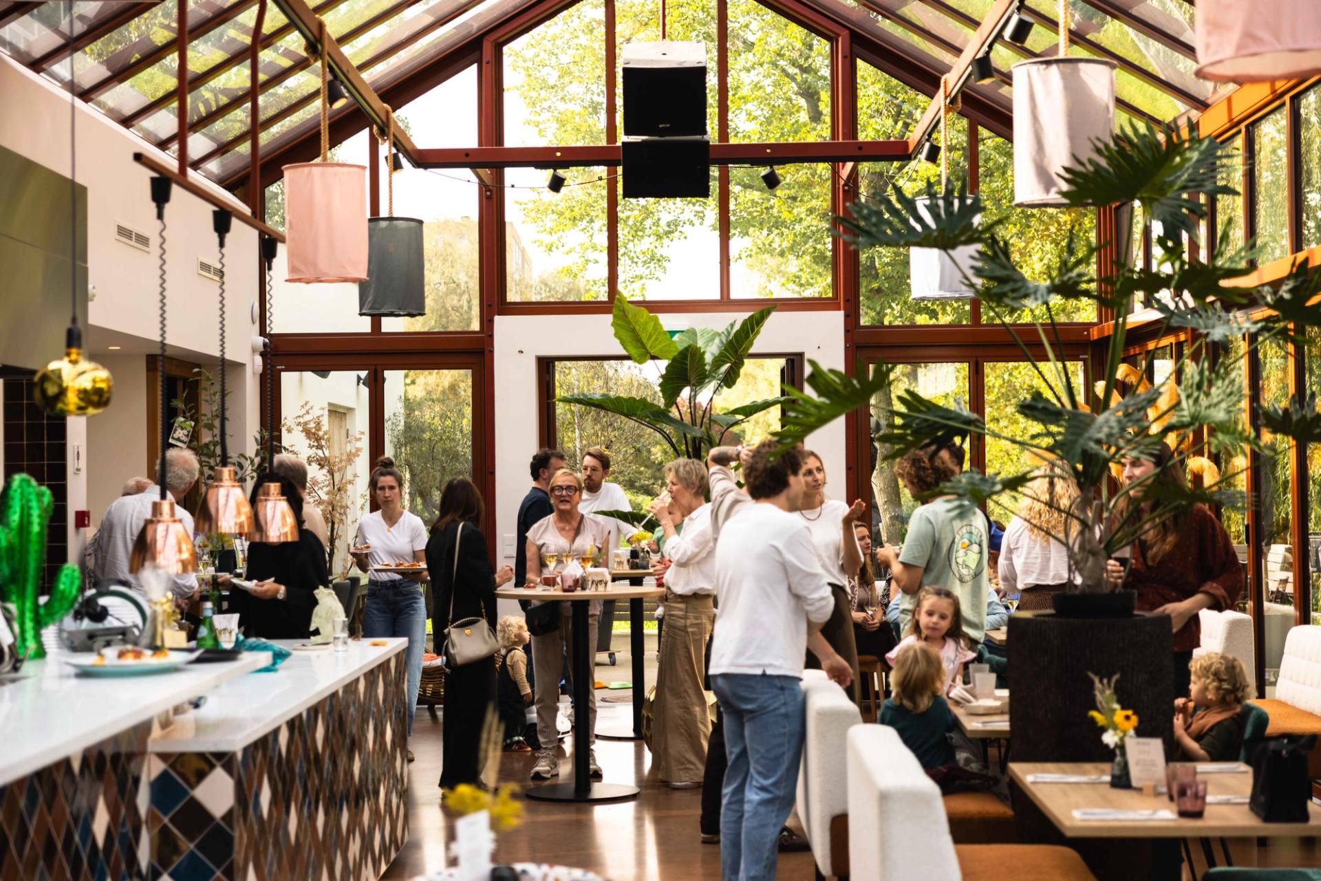 Restaurant van La Cocotte in Hoogvliet met glazen dak, betegelde bar en gedekte tafels