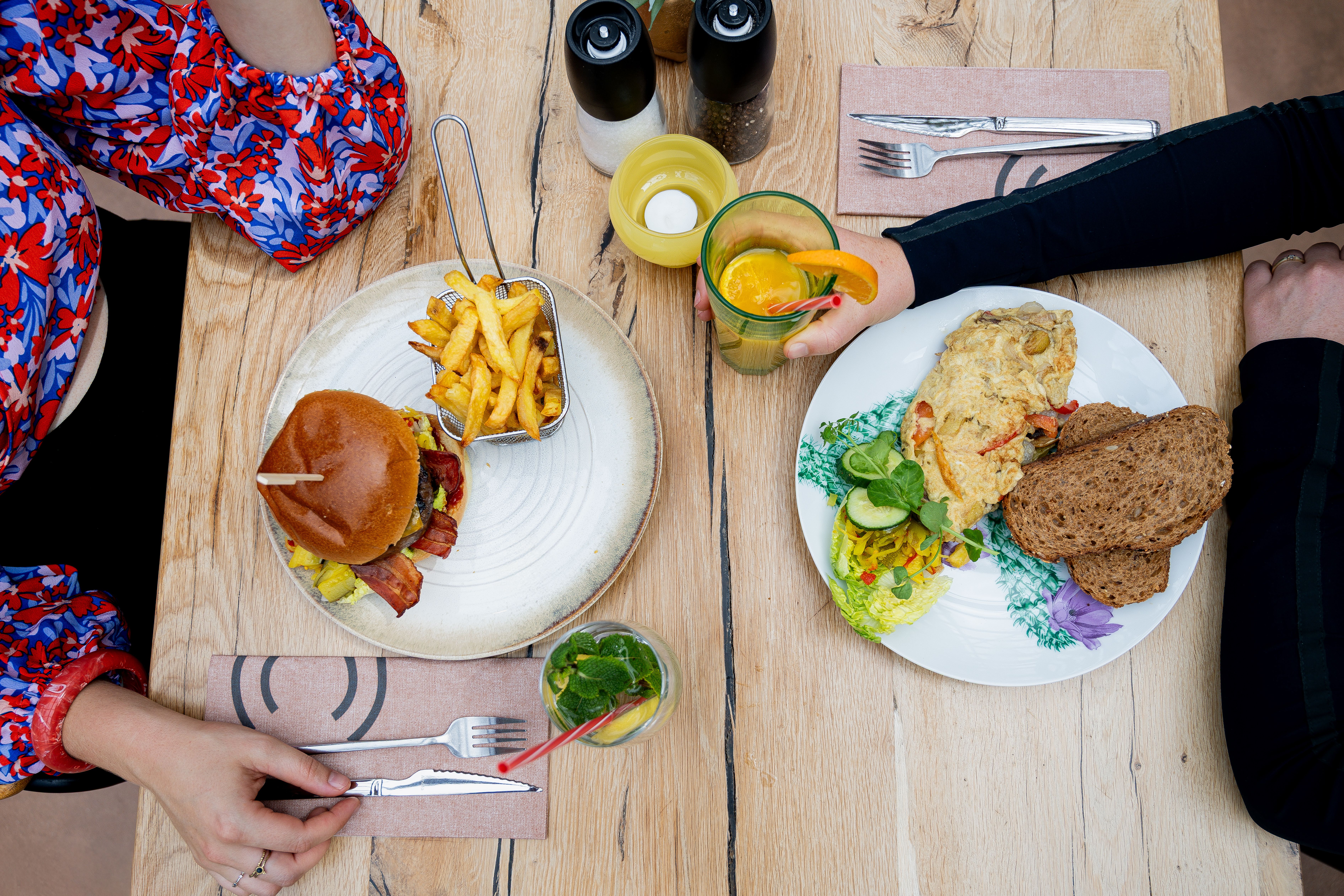 Twee gasten lunchen met een burger en een omelet bij La Cocotte in Hoogvliet Rotterdam