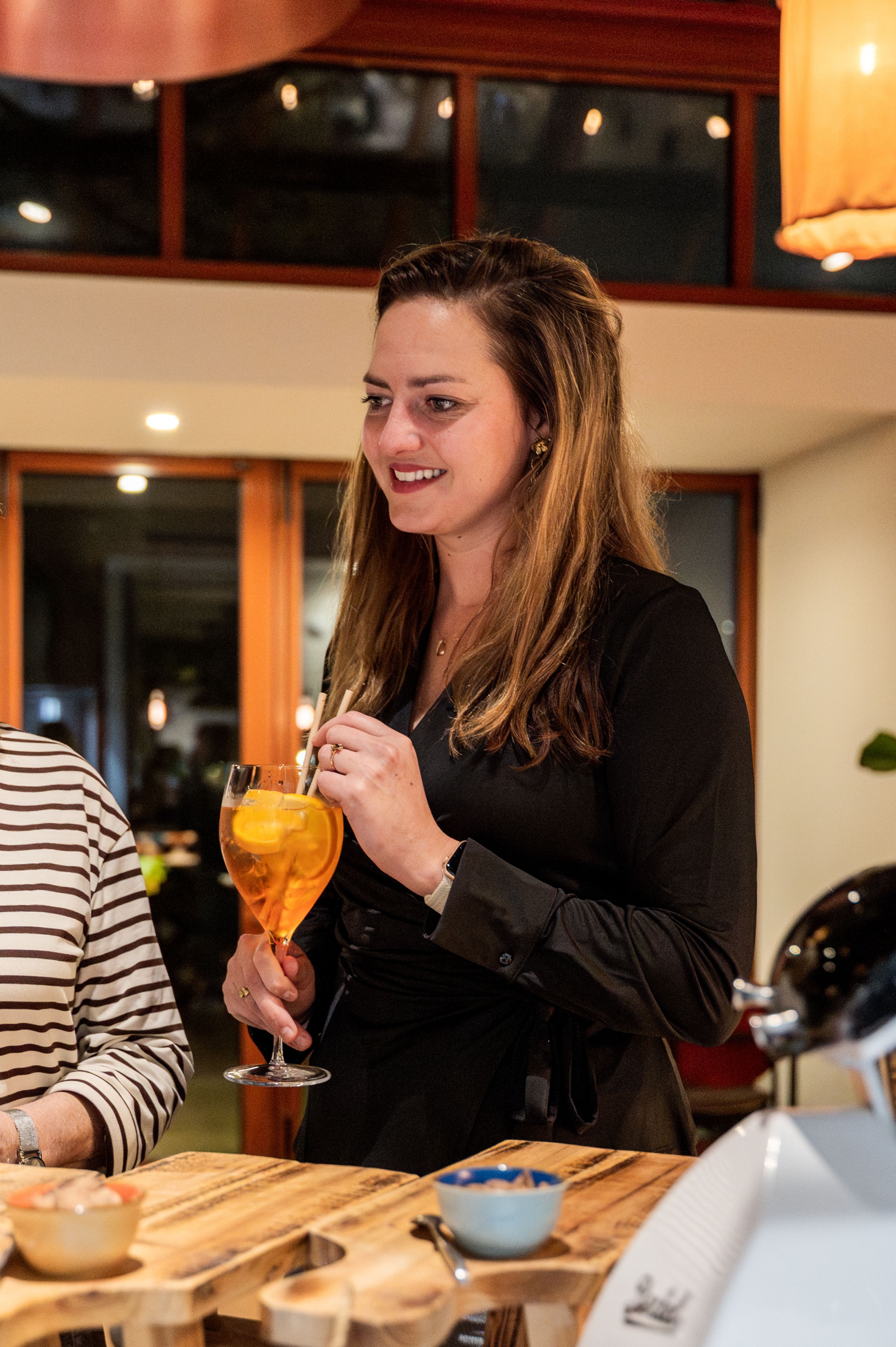 Vrouw met een Aperol Spritz in De Kas tijdens een pensioneringsborrel