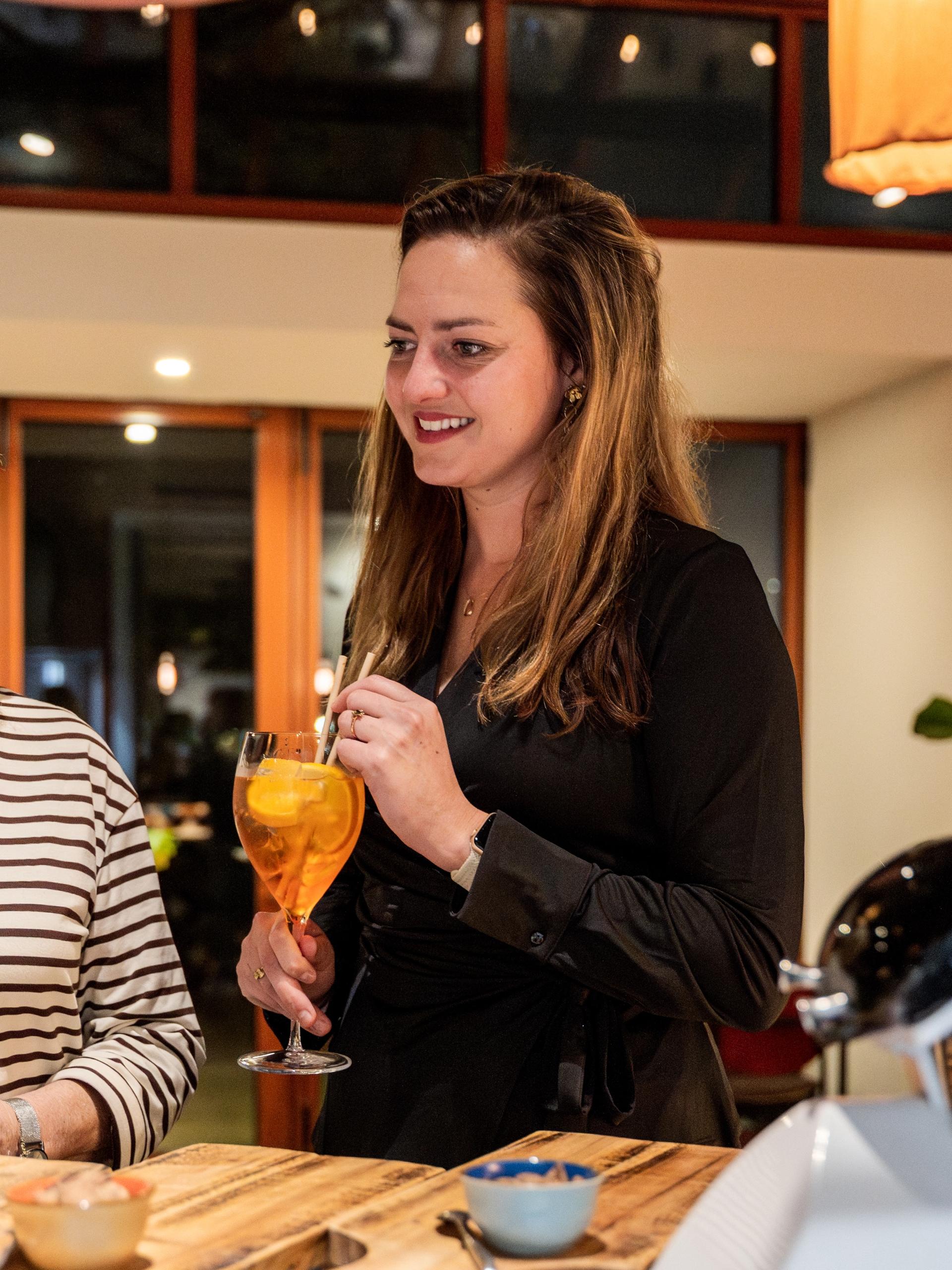 Vrouw met een Aperol Spritz in De Kas tijdens een pensioneringsborrel