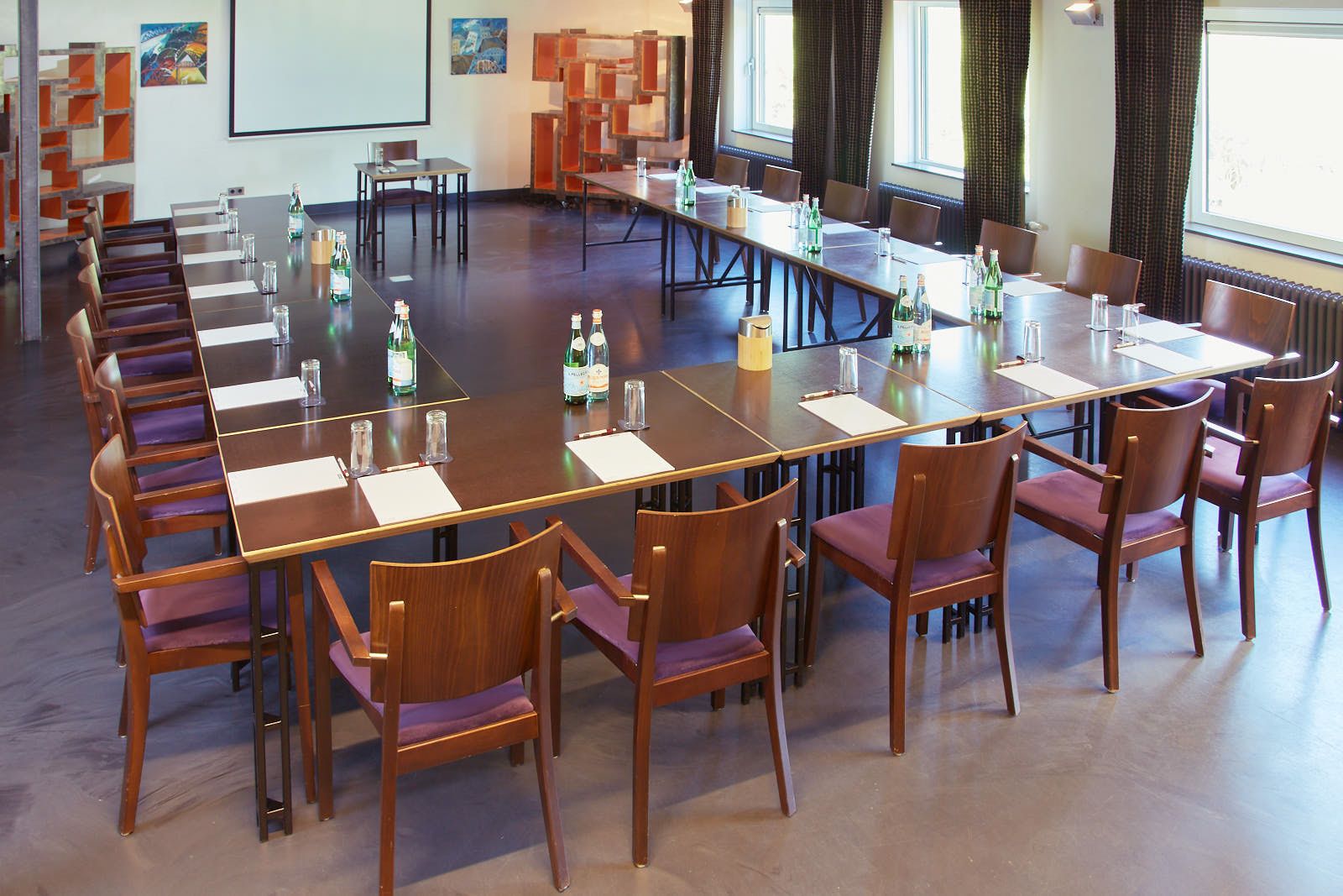 De Gaderingzaal van La Cocotte in carré-opstelling met projectiescherm, voor presentaties tot 80 personen