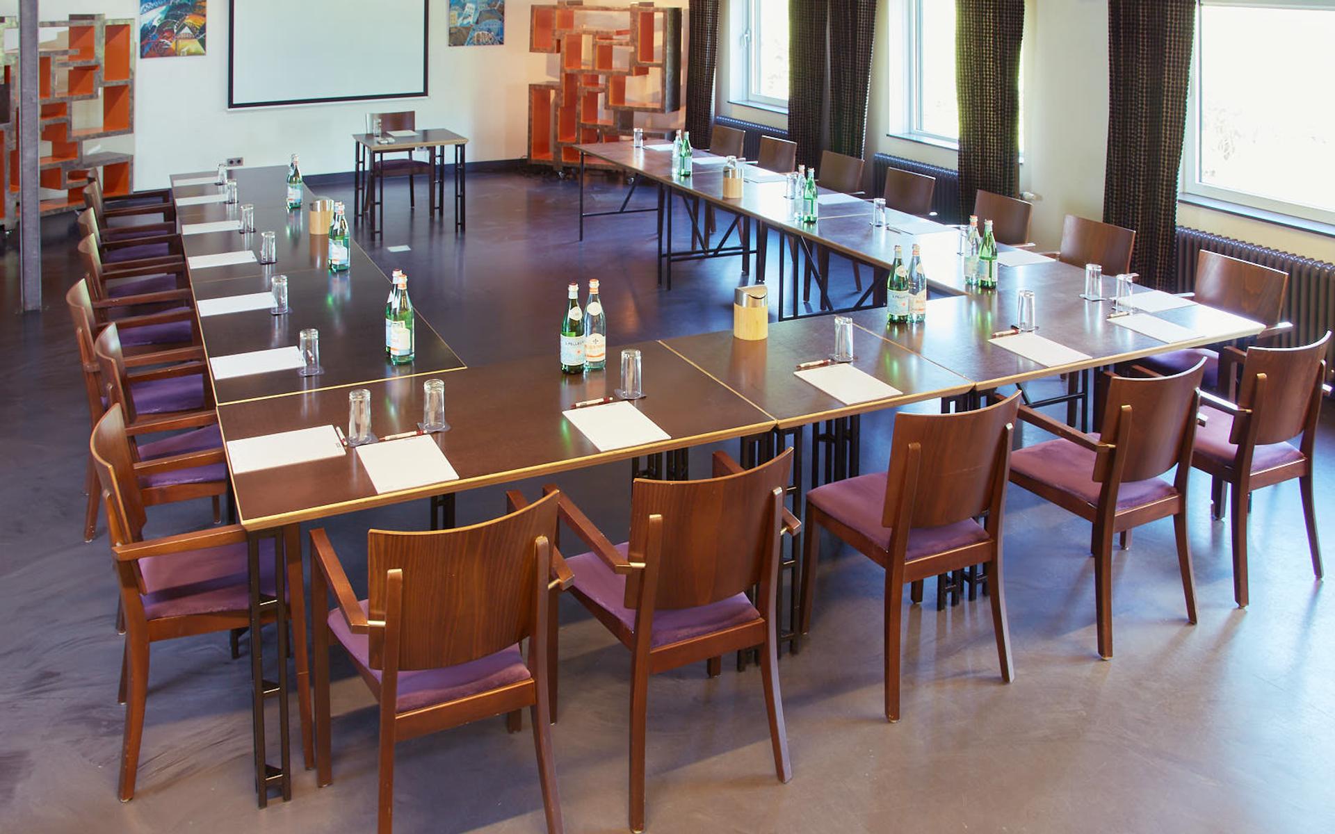 De Gaderingzaal van La Cocotte in carré-opstelling met projectiescherm, voor presentaties tot 80 personen