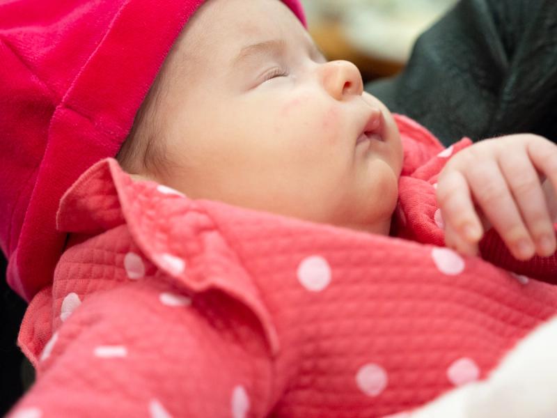 a baby sleeping dressed in pink