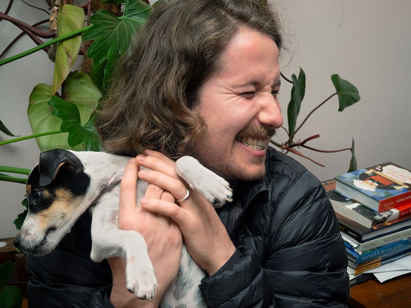 a man laughing holding a puppy 
