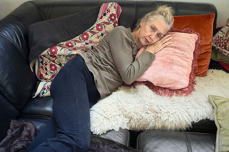 a woman lying on a couch with pillows
