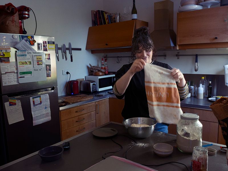 a woman making bread in a kitchen 