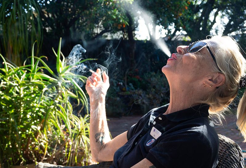 a woman smoking outside 